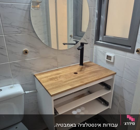כיור ושירותים בחדר אמבטיה עם ארון עץ